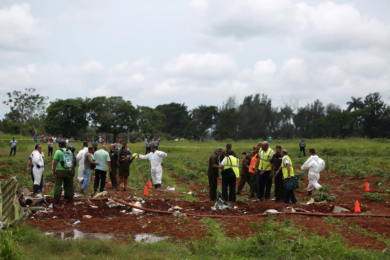 Les membres de l'équipe de sauvetage travaillent sur le site du crash. Plus de cent personnes ont péri dans le crash d'un Boeing 737 qui s'est écrasé vendredi peu après son décollage de La Havane à Cuba. /Photo prise le 18 mai 2018/REUTERS/Alexandre Meneghini