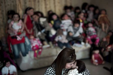 Natsuda Jantabtim, 45, kisses her "child angel" doll in Nonthaburi, Thailand, January 26, 2016. REUTERS/Athit Perawongmetha