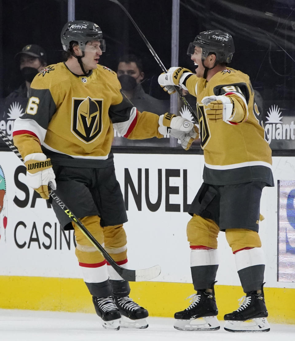 Vegas Golden Knights' Mattias Janmark, left, celebrates after Jonathan Marchessault, right, scored against the San Jose Sharks during the third period of an NHL hockey game Wednesday, April 21, 2021, in Las Vegas. (AP Photo/John Locher)