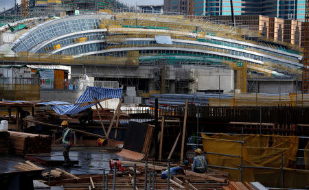 Laborers work in front of West Kowloon Terminus, under construction for the Guangzhou-Shenzhen-Hong Kong Express Rail Link, in Hong Kong, China July 21, 2017. REUTERS/Bobby Yip