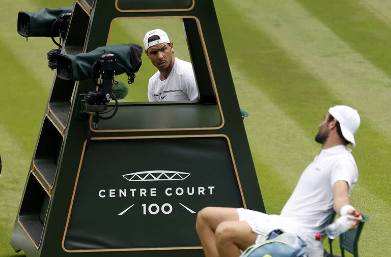 Rafael Nadal y Matteo Berrettini hablan durante la práctica que tuvieron en la cancha central de Wimbledon, que comenzará el próximo lunes.