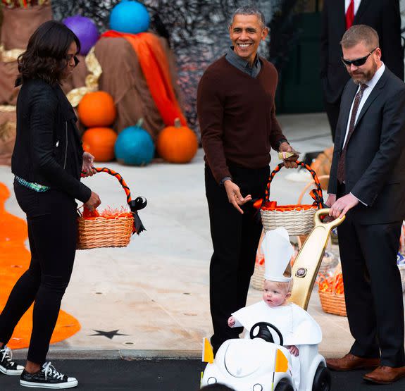 President Barack Obama and first lady Michelle Obama, left, greets a child dressed as the pope during Halloween festivities at the South Portico of the White House in Washington, Friday, Oct. 30, 2015. Obama and first lady Michelle Obama welcomed local children and children of military families to 'trick-or-treat' at the White House for Halloween. (AP Photo/Andrew Harnik)