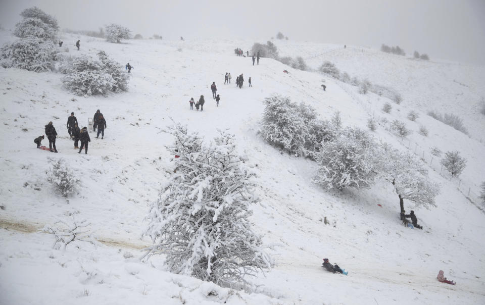 People exercise in the fresh snow at Wye National Nature Reserve near Ashford, southern England, Sunday Feb. 7, 2021. Heavy snow is predicted for the coming days and set to bring disruption to south-east England as bitterly cold winds grip much of the nation. (Andrew Matthews/PA via AP)