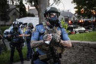 A police officer prepares to throw a tear gas canister towards protestors, Thursday, May 28, 2020, in St. Paul, Minn. Protests over the death of George Floyd, a black man who died in police custody Monday, broke out in Minneapolis for a third straight night. (AP Photo/John Minchillo)