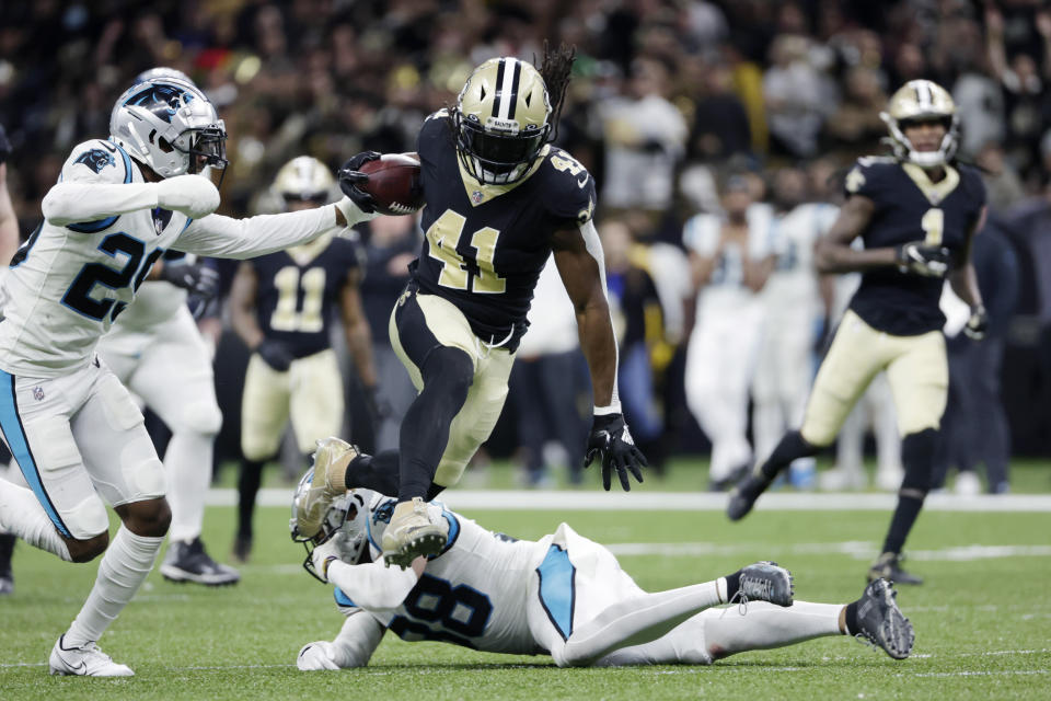 New Orleans Saints running back Alvin Kamara (41) carries for a long gain against Carolina Panthers cornerback Rashaan Melvin (29) and defensive back Myles Hartsfield (38) in the second half of an NFL football game in New Orleans, Sunday, Jan. 2, 2022. The Saints won 18-20. (AP Photo/Derick Hingle)