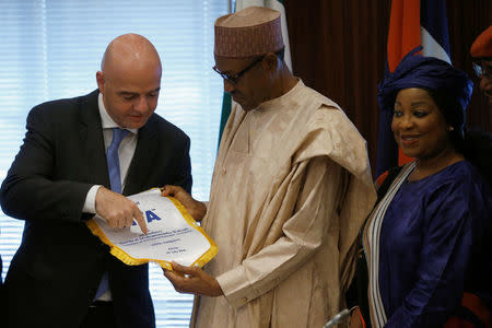 Nigerian President Muhammadu Buhari receives a present from FIFA President Gianni Infantino in Abuja, Nigeria, July 25, 2016. REUTERS/Afolabi Sotunde