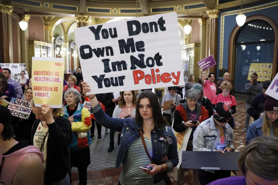 Marissa Messinger, of Lake View, Iowa, center, holds a sign during a rally to protest recent abortion bans, May 21, 2019, at the Statehouse in Des Moines, Iowa. (AP Photo/Charlie Neibergall, File)