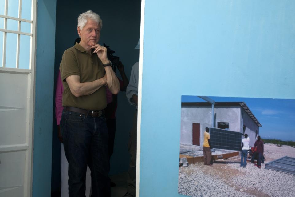 Former U.S. President and UN special envoy to Haiti Bill Clinton listens to members of the Union Des Apotres – Prodev School in Cite Soleil, Port-au-Prince, Haiti, Monday Feb. 17, 2014. Clinton is in Haiti to visit several projects that focus on agriculture and the environment, including the Union Des Apotres – Prodev solar-powered school that his private foundation has assisted and a training school for Haitian coffee farmers. (AP Photo/Dieu Nalio Chery)(AP Photo/Dieu Nalio Chery)