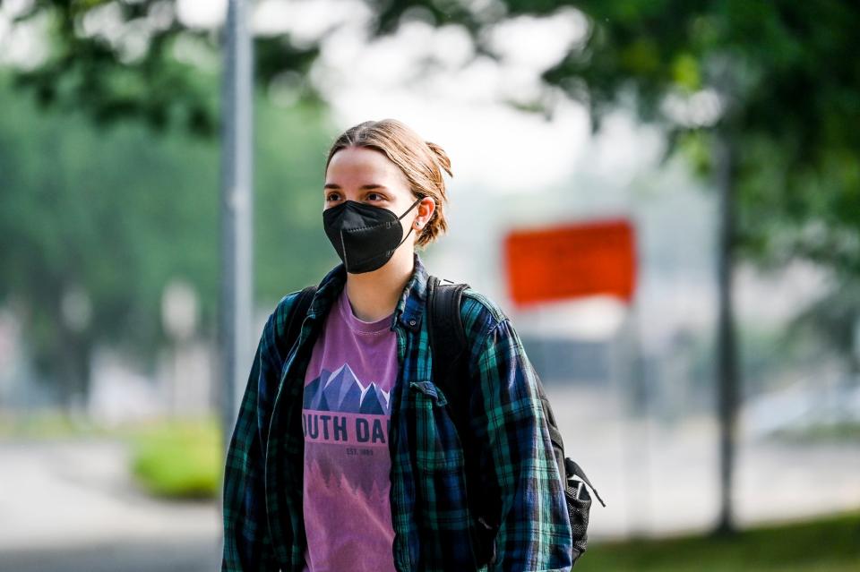 Michigan State University employee Kristen Lounsbury wears a mask to minimize exposure to the smoky air while walking on campus on Wednesday, June 28, 2023, in East Lansing.