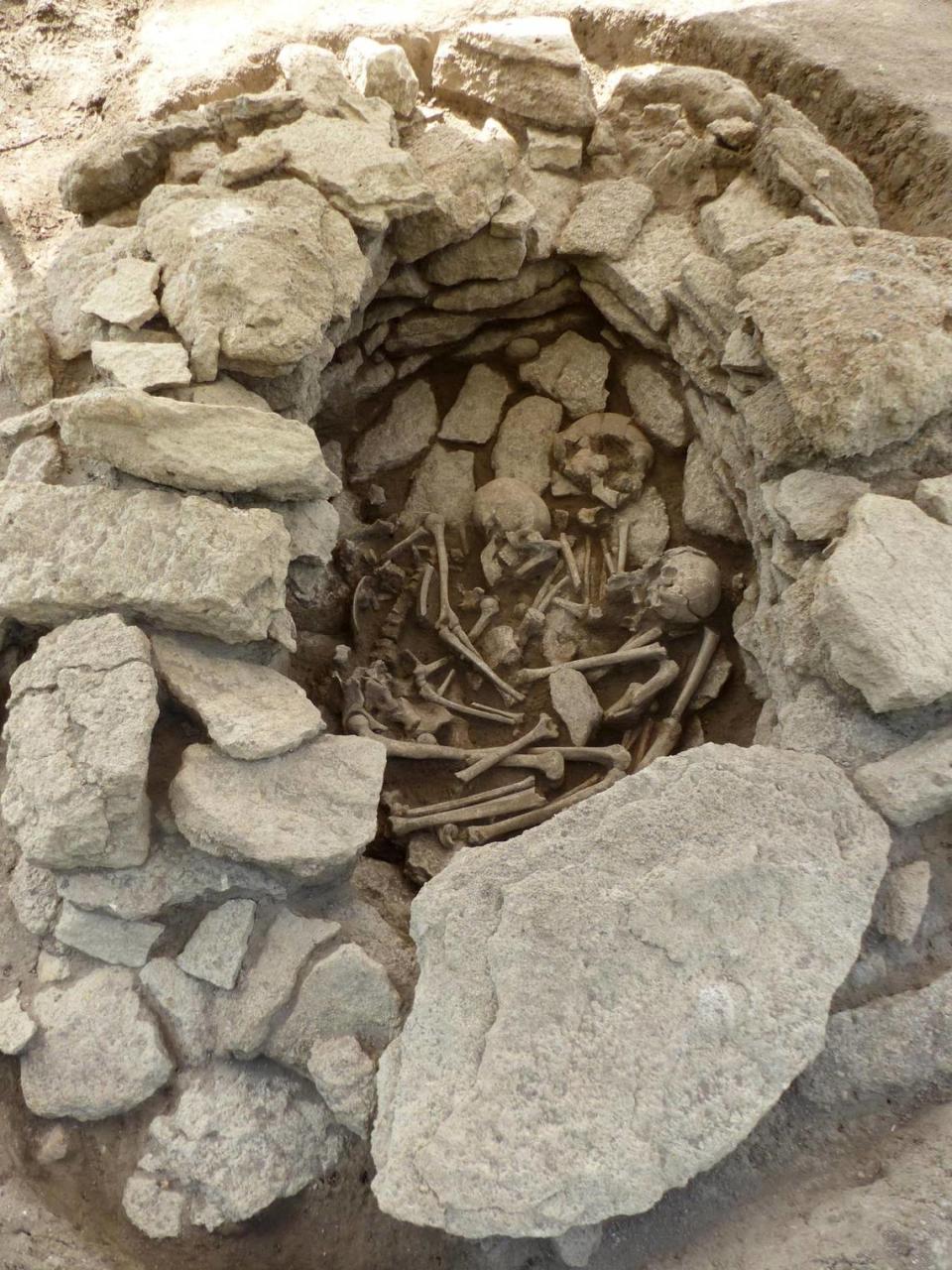 The remains of three people were found inside the stone burial, experts said.