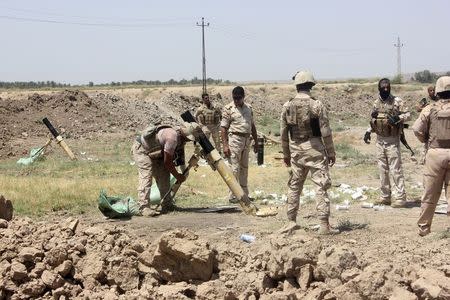 Members of the Iraqi security forces prepare to fire mortar bombs during clashes with Sunni militant group Islamic State of Iraq and the Levant (ISIL) in Muqdadiyah in Diyala province June 19, 2014. REUTERS/Stringer