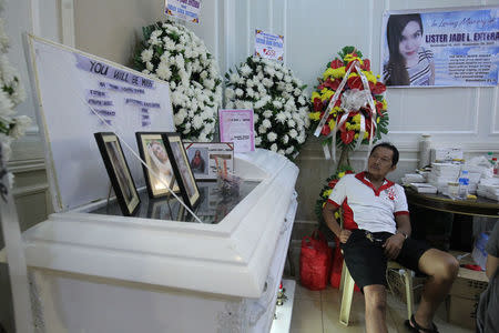 A man grieves near the coffin of her daughter, a call centre worker killed during a fire at a mall in Davao city, Philippines, December 28, 2017. REUTERS/Lean Daval Jr