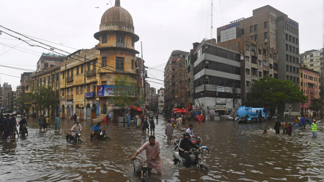 People wade across a flooded street after heavy monsoon rainfall in Karachi, Pakistan.