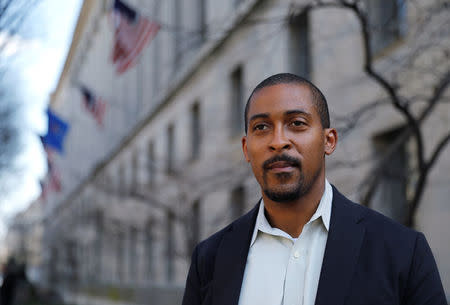 Johnathan Smith, formerly a staff attorney in the Civil Rights Division of the Obama Administration Justice Department, who is now the legal director of Muslim Advocates, stands in front of the U.S. Justice Department headquarters building where he used to work in Washington. REUTERS/Jim Bourg