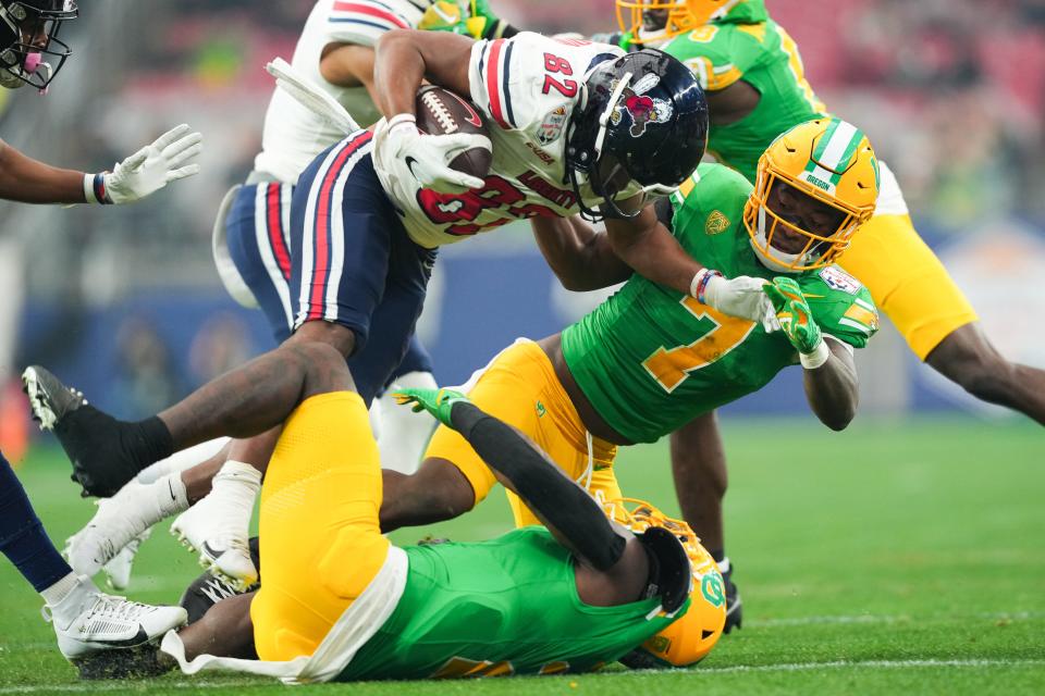 Liberty Flames wide receiver Aaron Bedgood (82) is tackled by Oregon Ducks defensive back Steve Stephens IV (7) during the first quarter in the 2024 Fiesta Bowl at State Farm Stadium Jan. 1, 2024, in Glendale, Arizona.