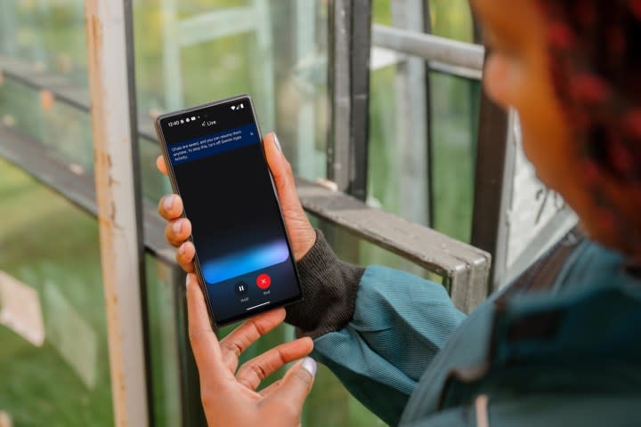 The photo shows a person holding a phone with the Google Gemini Live application.