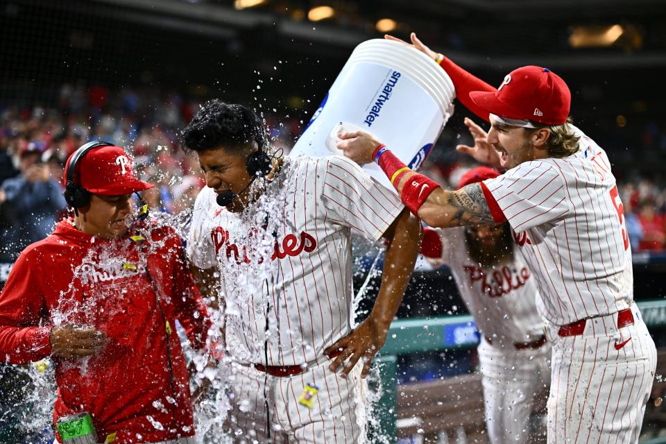 Philadelphia Phillies starting pitcher Ranger Suarez is showered by second baseman Bryson Stott (5) and outfielder Brandon Marsh (16) after pitching a complete game shutout against the Colorado Rockies at Citizens Bank Park.