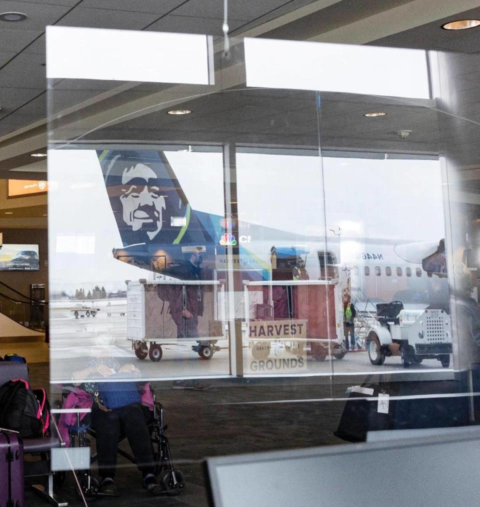 An Alaska Airlines plane reflected in a plexiglass barrier at the Boise Airport terminal.