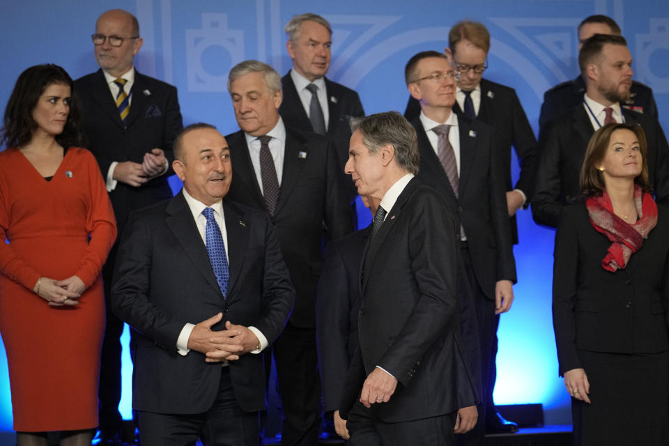 FILE - U.S. Secretary of State Antony Blinken, center, walks by Turkey's Foreign Minister Mevlut Cavusoglu before a family photo in Bucharest, Romania, on Nov. 29, 2022. Turkey and the United States will aim to smooth out a series of disagreements between the NATO allies when Turkey's foreign minister visits this week but expectations that outstanding issues can be resolved are slim. (AP Photo/Vadim Ghirda, File)