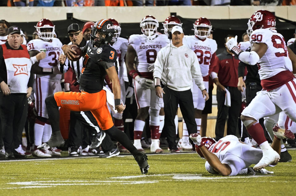 Oklahoma State quarterback Spencer Sanders (3) carries for a touchdown past Oklahoma defensive back Billy Bowman (5) and defensive lineman Josh Ellison during the second half of an NCAA college football game Saturday, Nov. 27, 2021, in Stillwater, Okla. (AP Photo/Sue Ogrocki)