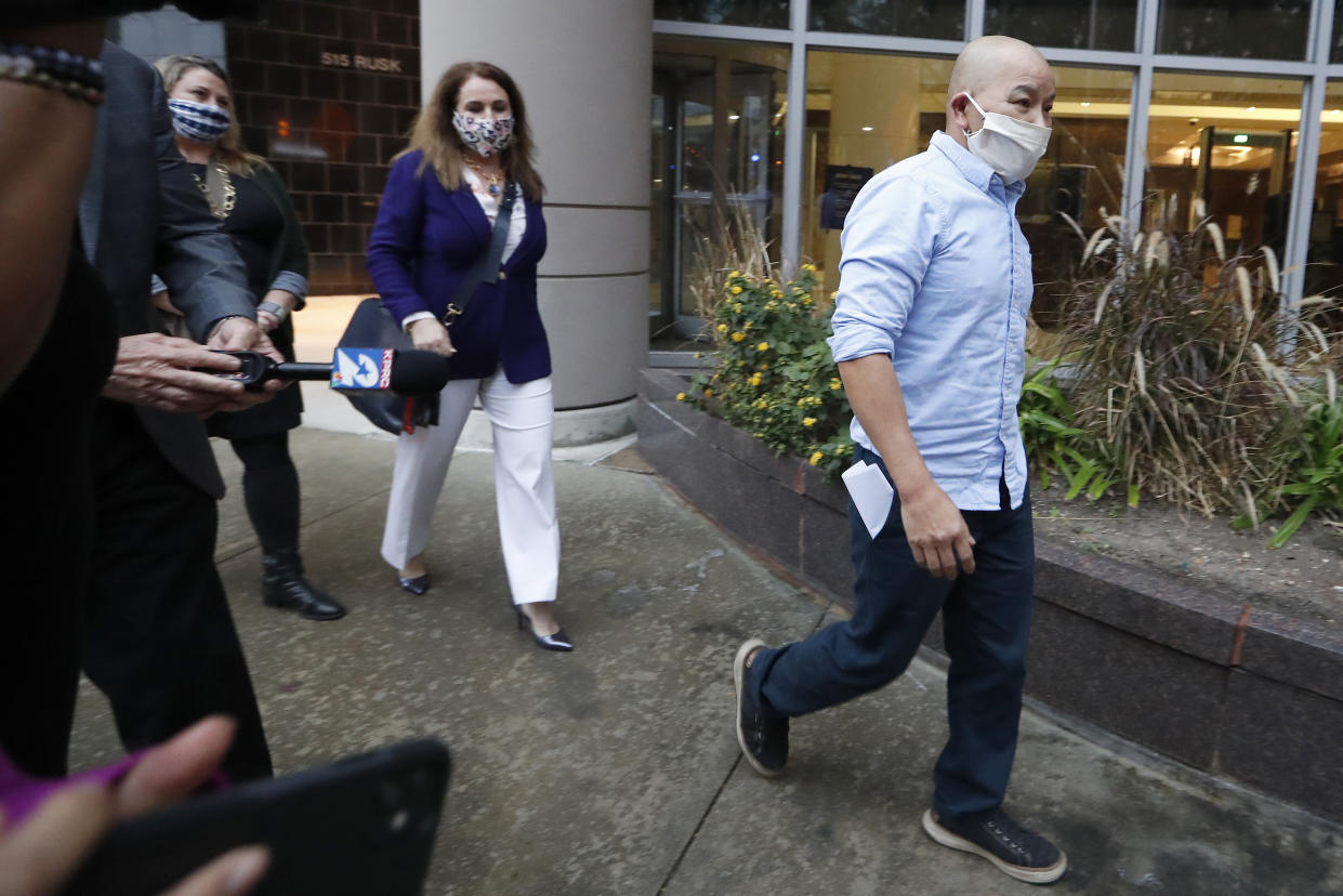 In this Jan. 21, 2021, photo former Houston Police Officer Tam Pham walks out of the Federal Courthouse downtown in Houston after he appeared in court following his arrest Wednesday on federal charges tied to Capitol violence. Police departments across the country are reviewing the behavior of dozens of officers who were in Washington on the day of a riot at the U.S. Capitol. (Karen Warren/Houston Chronicle via AP)