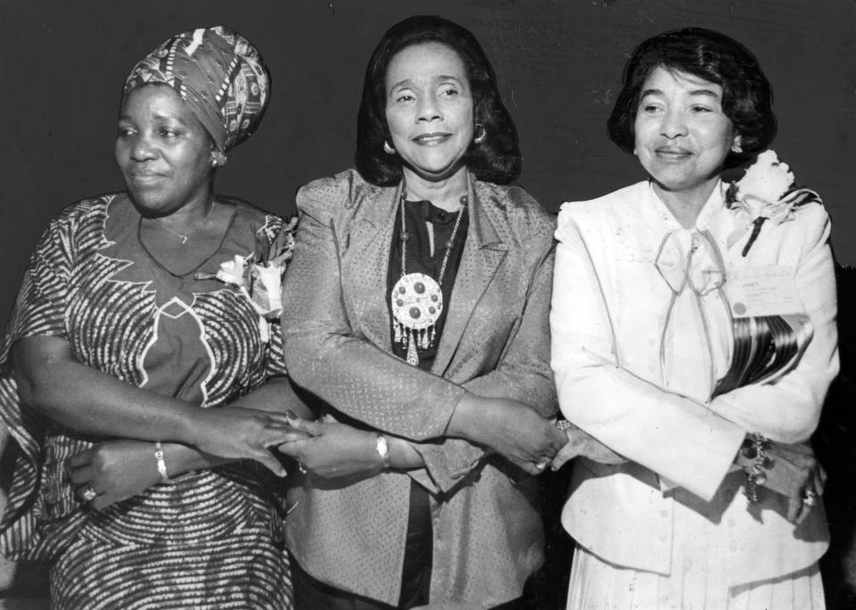American Civil Rights activist Coretta Scott King (1927 - 2006) (center) stands arms crossed and holding hands with two unidentified women at an unspecified event, August 1988. (Photo by Afro American Newspapers/Gado/Getty Images)