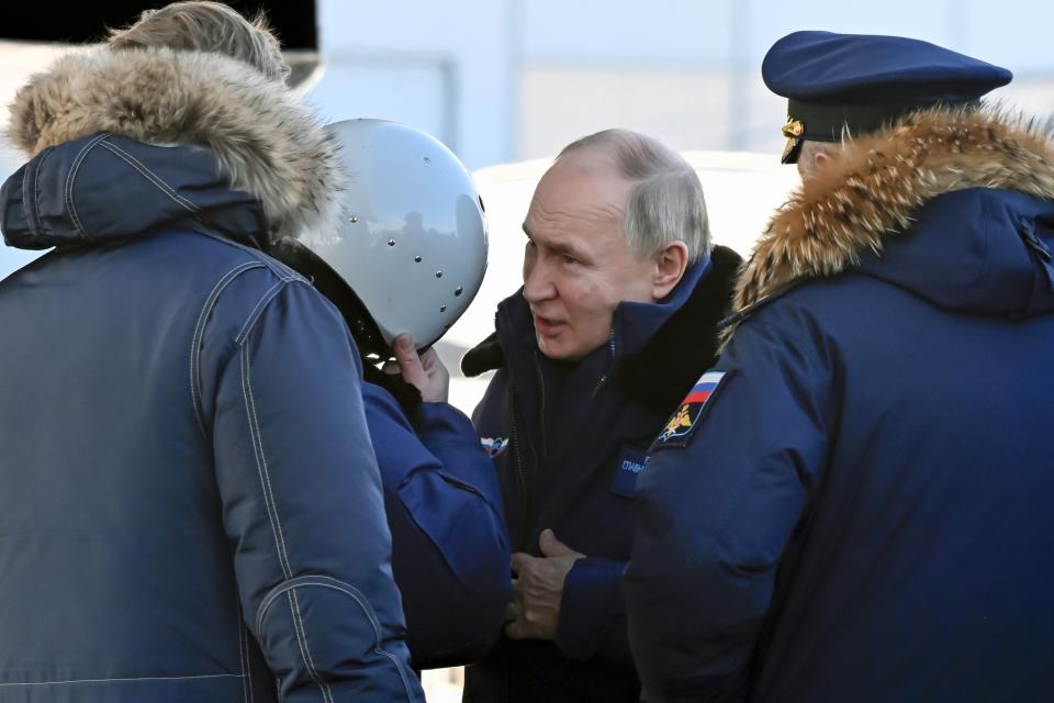 Russian President Vladimir Putin, center, speaks to a pilot as he boards a Tu-160M strategic bomber in Kazan, Russia, Thursday, Feb. 22, 2024. (Dmitry Azarov, Sputnik, Kremlin Pool Photo via AP)