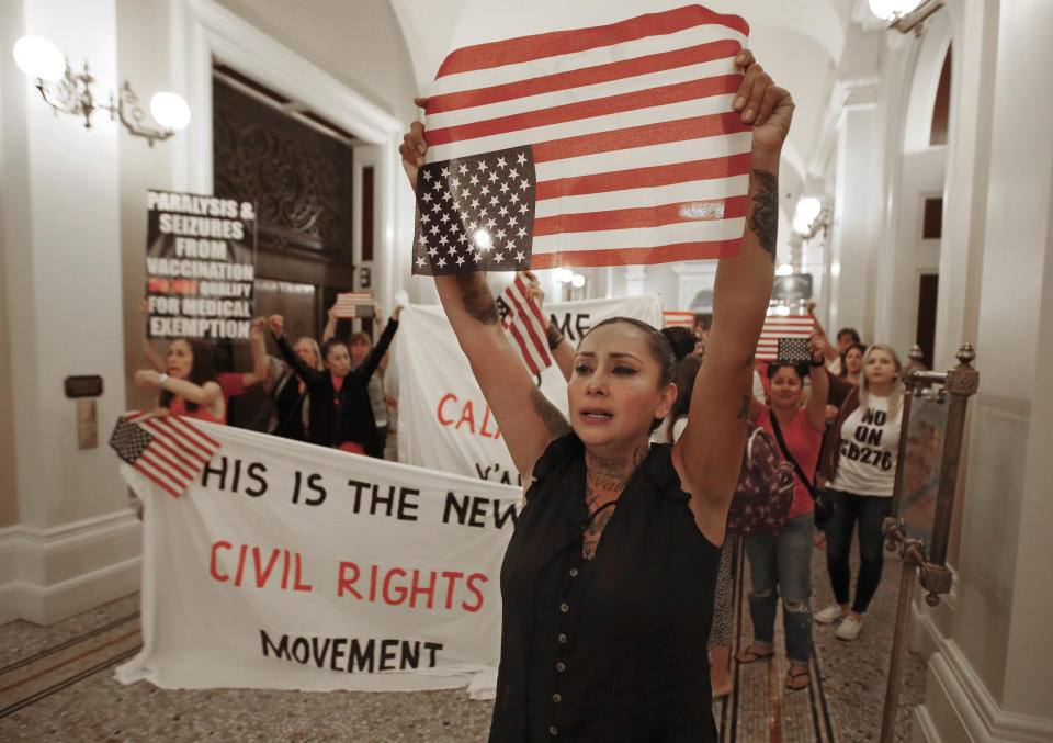 Denise Aguilar, right, joins others in a march through the Capitol to protest the state Legislature's passage of a measure to crack down on doctors who sell fraudulent medical exemptions for vaccinations, in Sacramento, Calif., Wednesday, Sept. 4, 2019. Lawmakers sent the bill to Newsom on Wednesday but he said he wants last-minute changes. (AP Photo/Rich Pedroncelli)