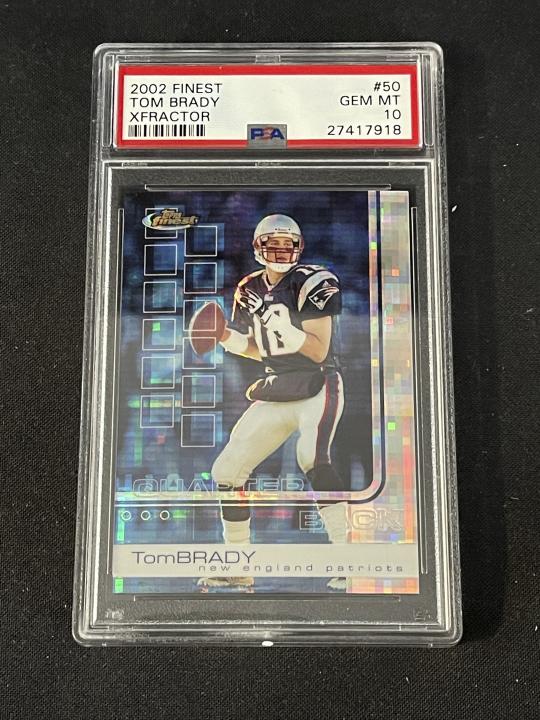 In this photo provided by Saco River Auction LLC, a 2002 Topps Finest X-Fractor card showing football quarterback Tom Brady rests inside a transparent case, Wednesday, Jan. 19, 2022, in Gorham, Maine. Troy Thibodeau from Saco River Auction estimates the card will fetch six figures when it's auctioned on Jan. 31. (Troy Thibodeau/Saco River Auction LLC via AP)