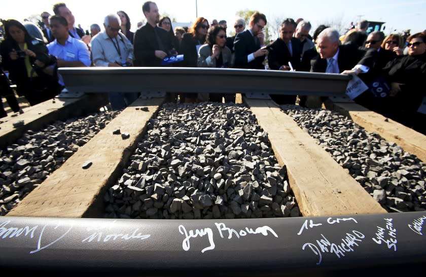 Guests sign a rail segment during a groundbreaking ceremony for a bullet train station in Fresno on Jan. 6.