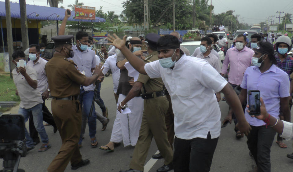 Police try to stop supporters of Sri Lanka's Tamil National Alliance parading in Addalaichenai, Sri Lanka, Wednesday, Feb. 3, 2021.Sri Lanka's ethnic Tamil leaders and civilians started a four-day protest parade from the east to the north on Wednesday to coincide with the country's 73rd independence anniversary, demanding justice for civilians killed and forcibly disappeared allegedly at the hands of the government military.(AP Photo/Achala Upendra)