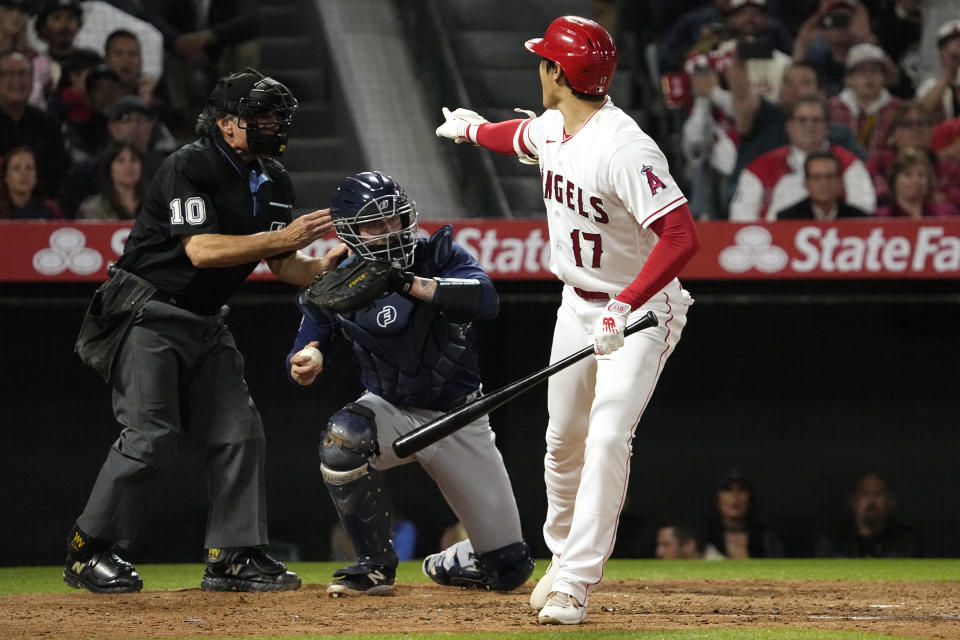 Los Angeles Angels' Shohei Ohtani, right, complains about a called strike three as home plate umpire Phil Cuzzi, left stands by and Seattle Mariners catcher Tom Murphy throws the ball back during the fifth inning of a baseball game Saturday, June 10, 2023, in Anaheim, Calif. (AP Photo/Mark J. Terrill)