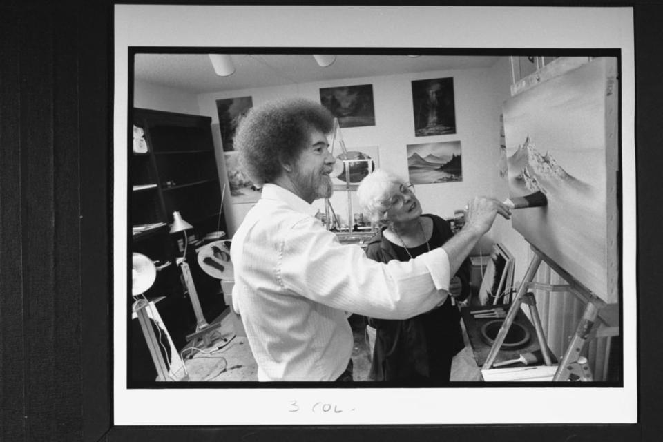 <div class="inline-image__caption"><p>Bob Ross at easel painting one of his mountain landscapes as his business partner Annette Kowalski looks on in his studio at home.</p></div> <div class="inline-image__credit">Acey Harper/Getty</div>