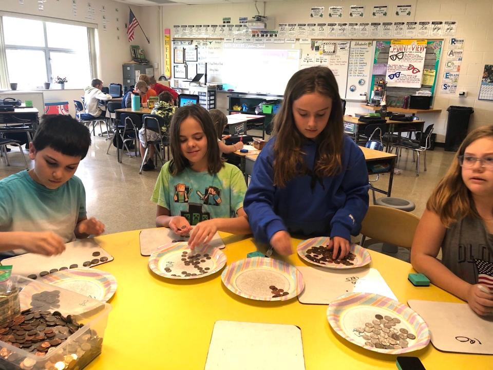 From left, Damien Salerno, Haileigh Helminiak, Ivy Brielmaier and Natalie Braman, all fourth graders at Sand Creek's Ruth McGregor Elementary School, count up coins last week during the school's Money Wars fundraiser, which was developed by teacher Caitlyn Hella's class as part of its social and emotional learning curriculum and service learning project.