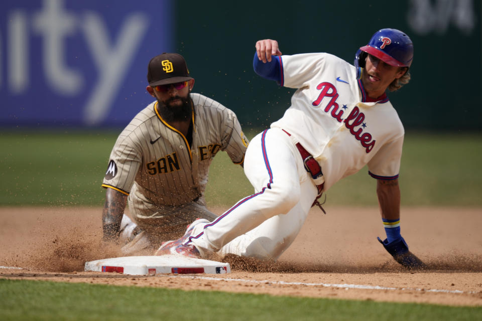 Philadelphia Phillies' Bryson Stott, right, slides into third past San Diego Padres third baseman Rougned Odor to advance on a single by Brandon Marsh during the eighth inning of the first baseball game in a doubleheader, Saturday, July 15, 2023, in Philadelphia. (AP Photo/Matt Slocum)