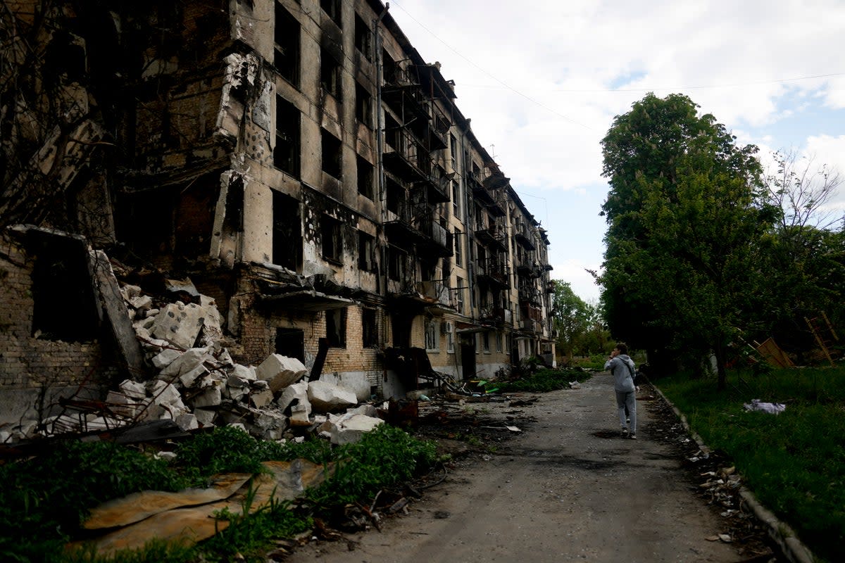 A man walks in front of a damage building ruined by attacks in Hostomel on the outskirts of Kyiv (Natacha Pisarenko/AP/PA) (AP)