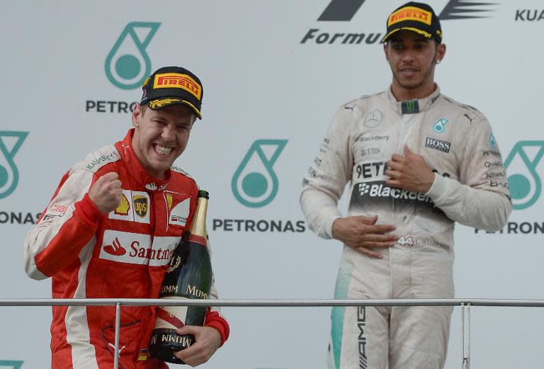 Sebastian Vettel (left) celebrates on the podium in front of Lewis Hamilton after the Malaysian Grand Prix in Sepang on March 29, 2015
