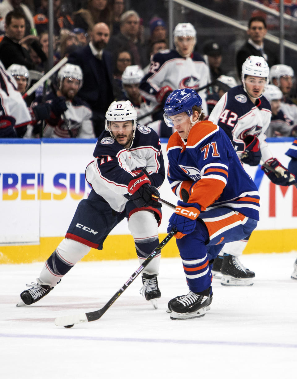 Columbus Blue Jackets' Justin Danforth (17) checks Edmonton Oilers' Ryan McLeod (71) during the second period of an NHL hockey game in Edmonton, Alberta, Tuesday, Jan. 23, 2024. (Amber Bracken/The Canadian Press via AP)