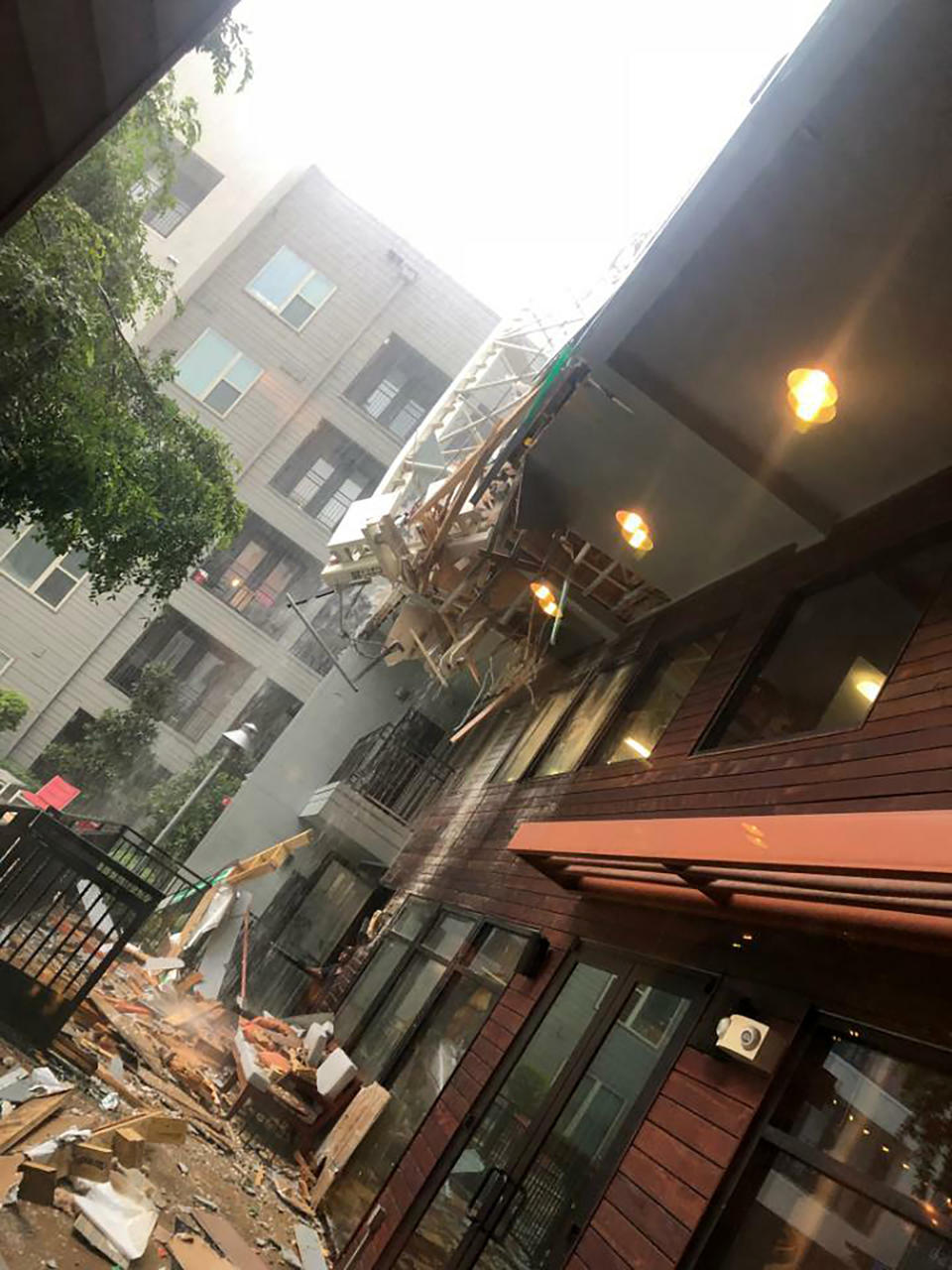 This photo taken and provided by Michael Santana shows the damage after a construction crane toppled on an apartment building as it was buffeted by high winds during a storm in Dallas, Texas, Sunday, June 9, 2019. (Michael Santana via AP)