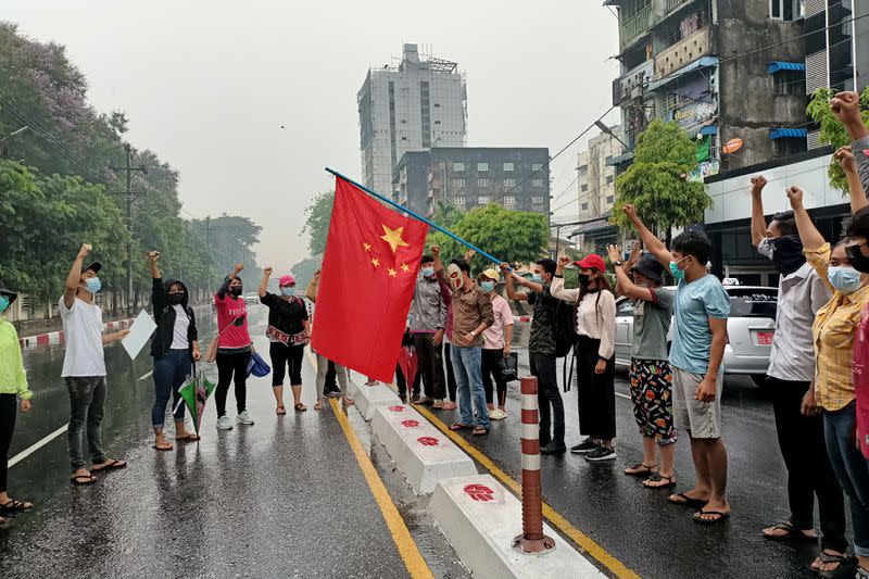 Anti-coup protesters hold Chinese flag in Yangon