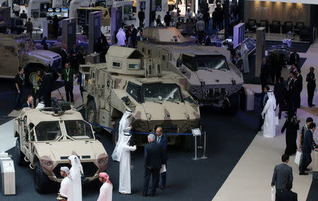Visitors look at vehicles on display during the International Defence Exhibition and Conference (IDEX) in Abu Dhabi, United Arab Emirates February 19, 2017. REUTERS/Stringer