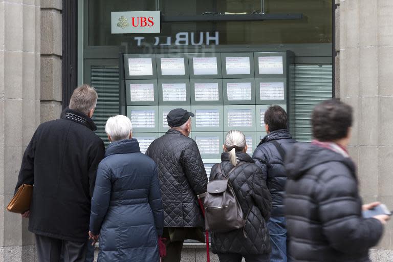 People look at exchange rate boards at UBS bank in Zurich on January 15, 2015, after Switzerland's central bank scrapped a policy to artificially hold down the value of the Swiss franc against the euro