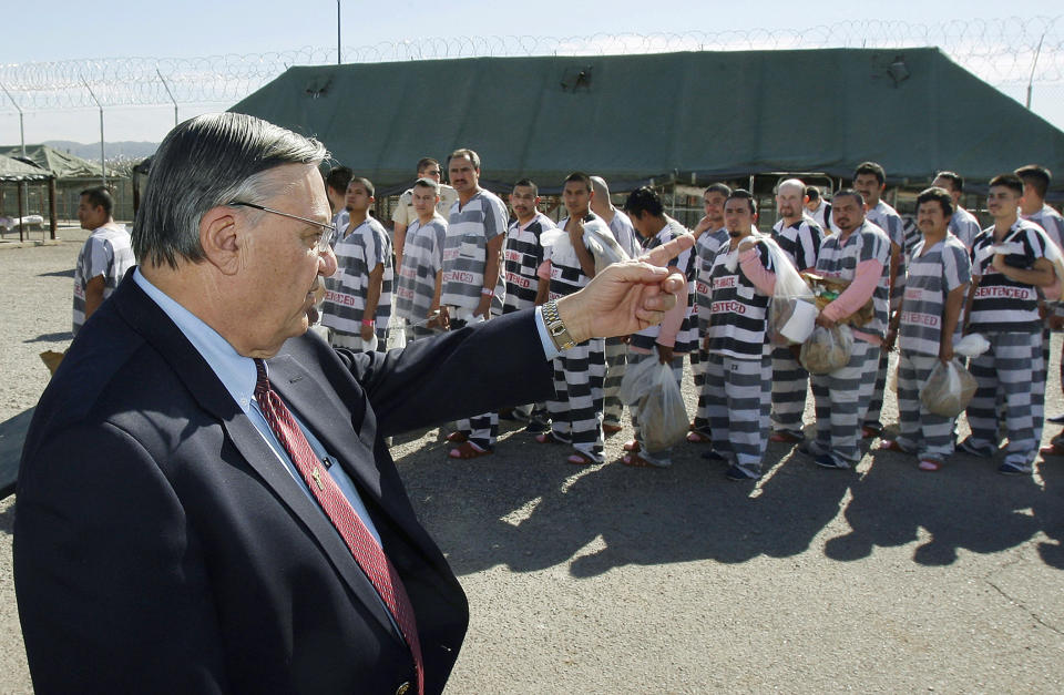 FILE - In this Feb. 4, 2009, file photo, Maricopa County Sheriff Joe Arpaio, left, orders approximately 200 convicted illegal immigrants handcuffed together and moved into a separate area of Tent City for incarceration until their sentences are served and they are deported to their home countries, in Phoenix. Arpaio, 87, is trying to regain his previous job as metro Phoenix's sheriff. The former lawman, who became a lightning rod for his hardline policies on illegal immigration, doesn't need the money and denies he's running to stroke his ego or garner publicity. Instead, he says he wants to do whatever he can to support President Donald Trump and vows to bring back his immigration crackdowns and jail tents. (AP Photo/Ross D. Franklin, File)