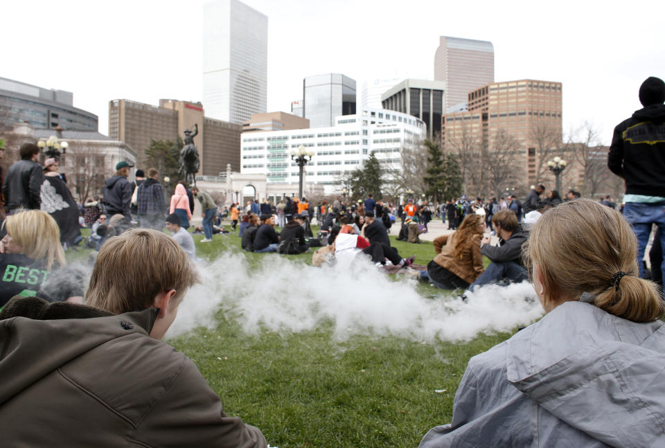 FILE - People smoke marijuana during the annual 4/20 marijuana gathering at Civic Center Park in downtown Denver, Wednesday, April 20, 2016. Marijuana advocates are gearing up for Saturday, April 20, 2024. Known as 4/20, marijuana's high holiday is marked by large crowds gathering in parks, at festivals and on college campuses to smoke together. This year, activists can reflect on how far the movement has come. (AP Photo/Brennan Linsley, File)