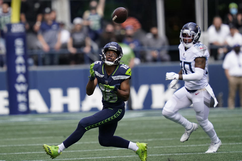 Seattle Seahawks wide receiver Tyler Lockett (16) catches a pass before running for a touchdown in from of Tennessee Titans strong safety Bradley McDougald, right, during the first half of an NFL football game, Sunday, Sept. 19, 2021, in Seattle. (AP Photo/Elaine Thompson)