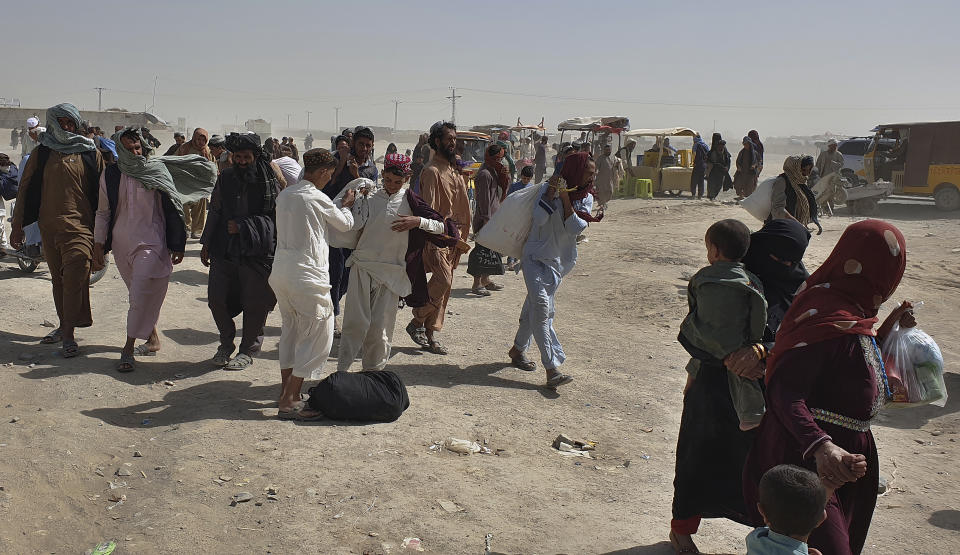 Stranded people gather and wait to open the border which was closed by authorities, in Chaman, Pakistan, Saturday, Aug. 7, 2021. Chaman border crossing is one of busiest border crossings between Pakistan and Afghanistan. Thousands of Afghans and Pakistanis cross daily and a steady stream of trucks passes through, taking goods to land-locked Afghanistan from the Arabian Sea port city of Karachi in Pakistan. (AP Photo/Tariq Achakzai)