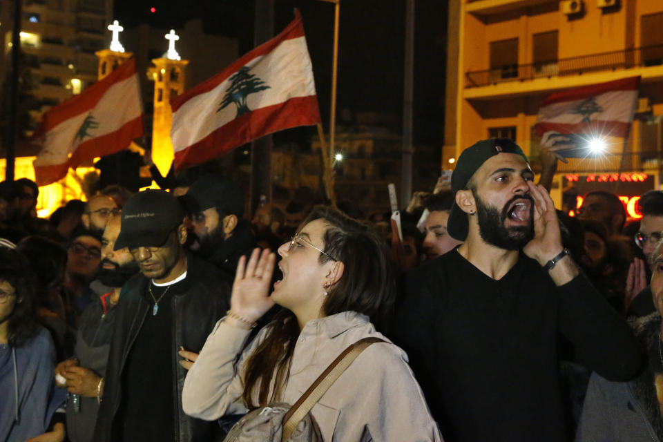 Protesters chant slogans and hold their national flags as they block a highway during an anti-government protest in Beirut, Lebanon, Wednesday, Dec. 4, 2019. Protesters have been holding demonstrations since Oct. 17 demanding an end to corruption and mismanagement by the political elite that has ruled the country for three decades. (AP Photo/Bilal Hussein)
