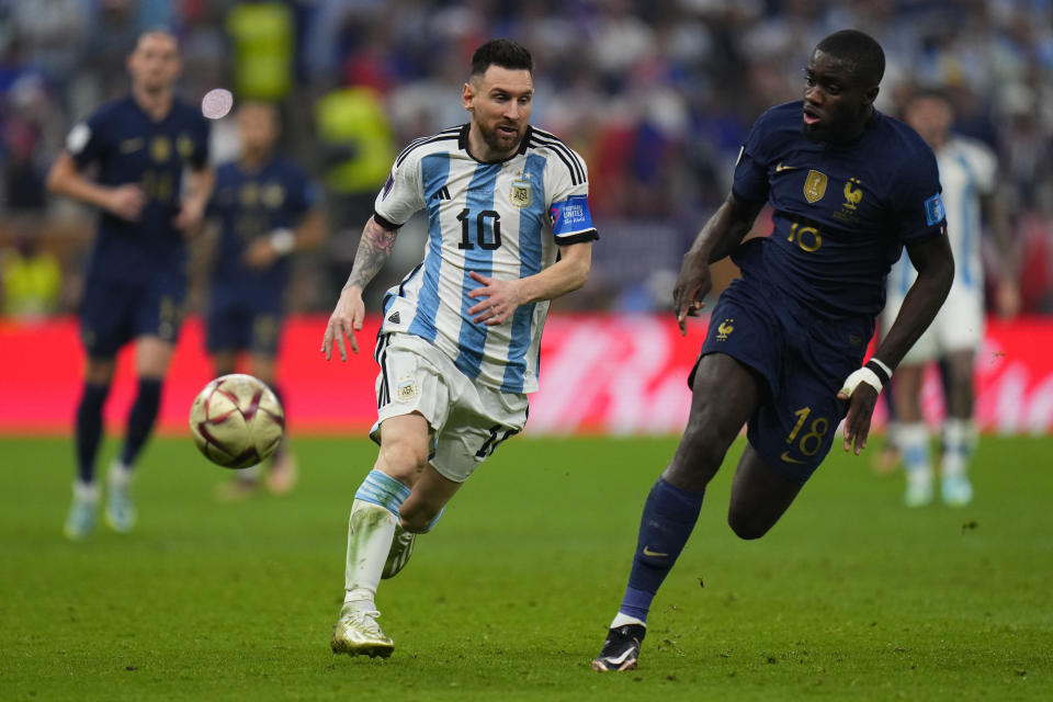 Argentina's Lionel Messi, left, and France's Youssouf Fofana run for the ball during the World Cup final soccer match between Argentina and France at the Lusail Stadium in Lusail, Qatar, Sunday, Dec. 18, 2022. (AP Photo/Petr David Josek)