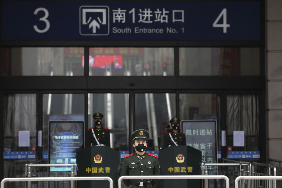 FILE - In this Jan. 23, 2020, file photo, Chinese paramilitary police stand guard outside the closed Hankou Railway Station in Wuhan in central China's Hubei Province. Cutting off access to entire cities with millions of residents to stop a new virus outbreak is a step few countries other than China would consider, but it is made possible by the ruling Communist Party's extensive social controls and experience fighting the 2002-03 outbreak of SARS. (Chinatopix via AP, File)