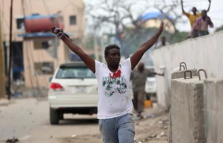 A man raises his hands as he walks from the scene of a suicide car bombing outside Nasahablood hotel in Somalia's capital Mogadishu, June 25, 2016. REUTERS/Feisal Omar